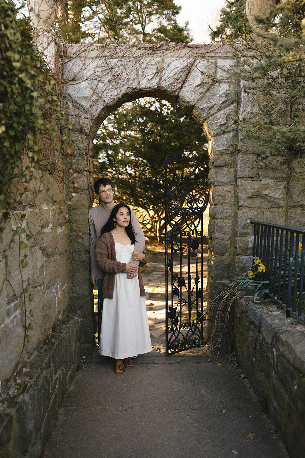 Gaby and Corey framed by a gorgeous arch found within the gardens at Harkness Memorial State Park