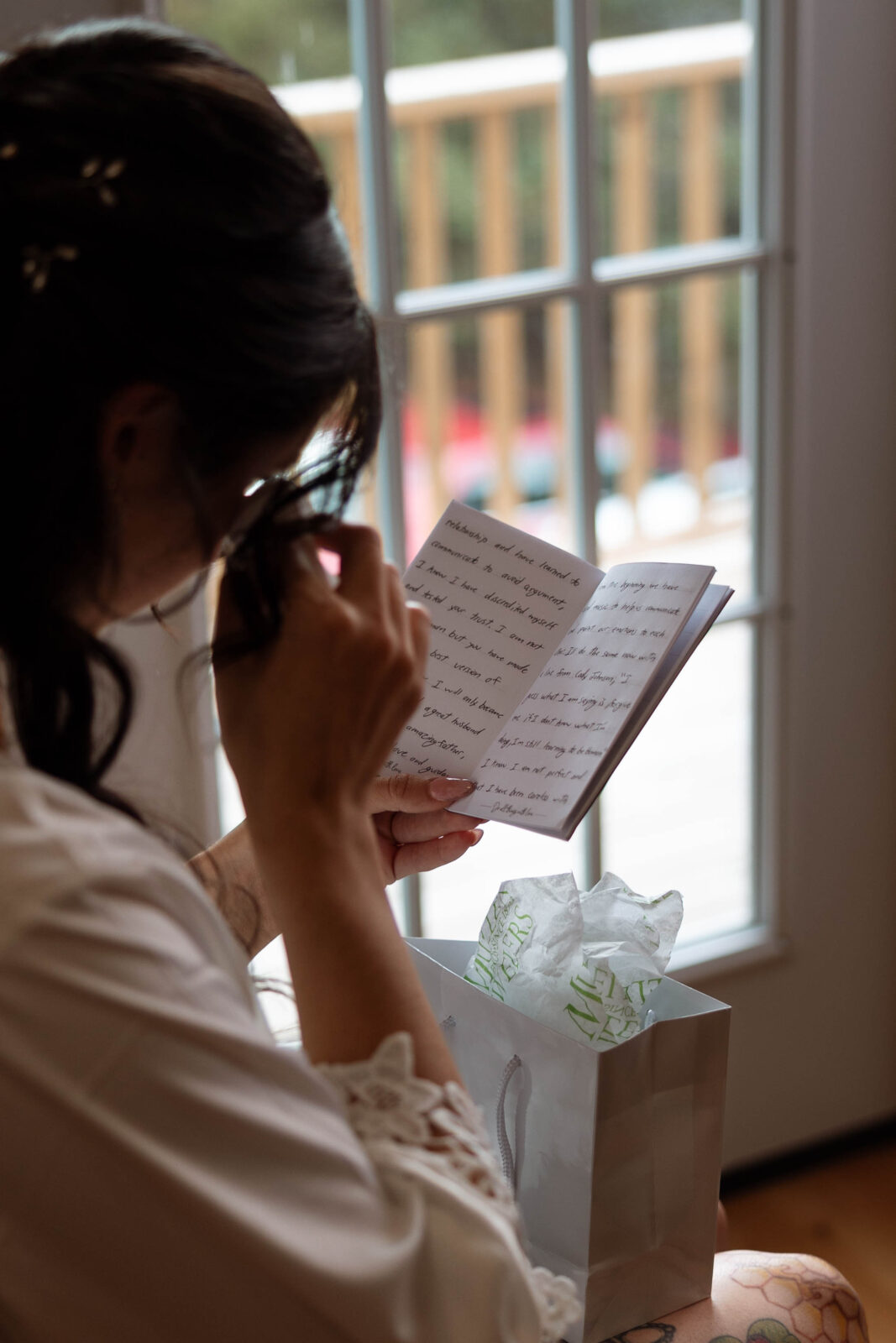 Caitlin getting ready in a cozy room with natural light streaming in.
