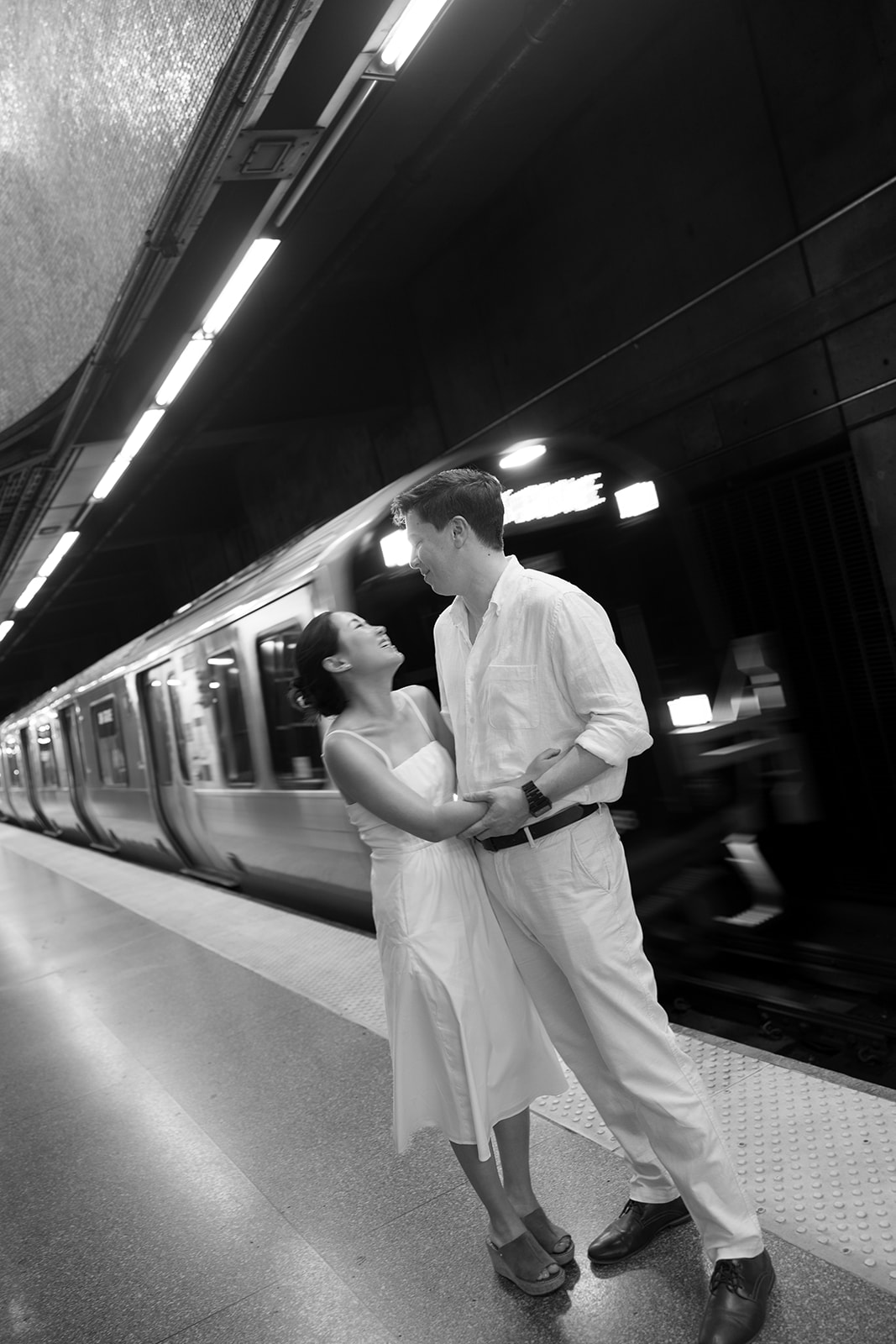Jess & Reid holding each other waiting for the train